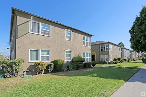 A row of houses with green lawns in front.