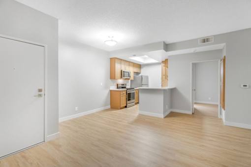 A kitchen with white walls and wooden floors.