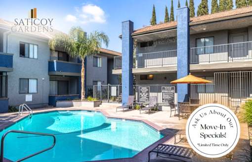 A pool surrounded by buildings with a sign that says "Ask Us About Our Move-In Specials!".