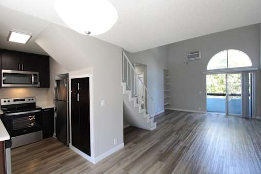A modern kitchen with dark wood cabinets and stainless steel appliances.