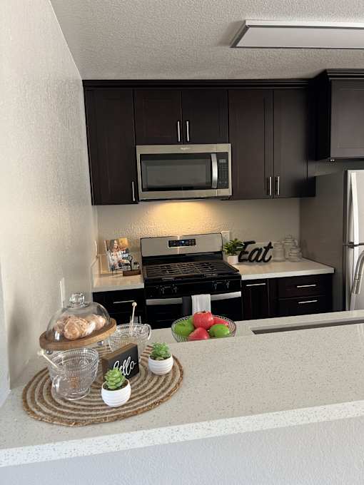 a kitchen with black cabinets and a counter with food on it