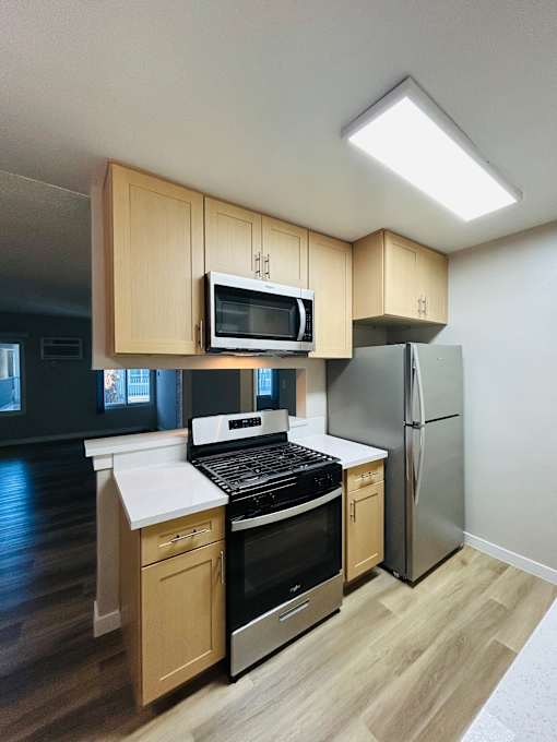 A kitchen with wooden cabinets and a black stove top oven.