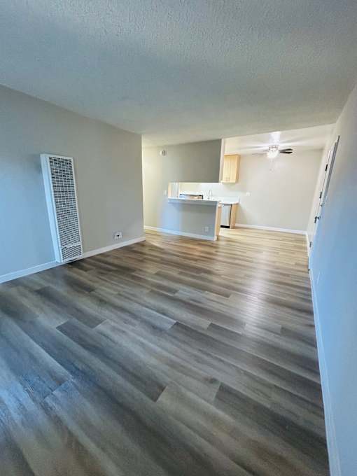 A room with wooden flooring and a white wall.