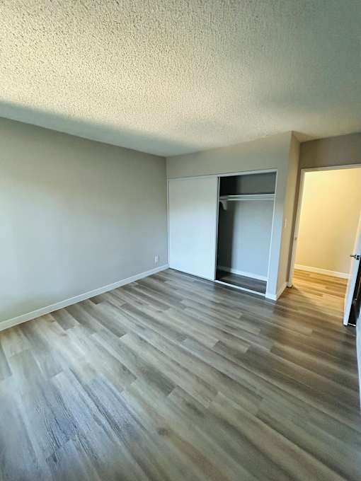 A room with a wooden floor and a white wall.