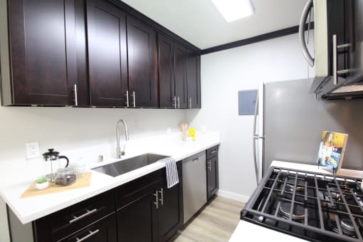 a kitchen with black cabinets and stainless steel appliances and a stove