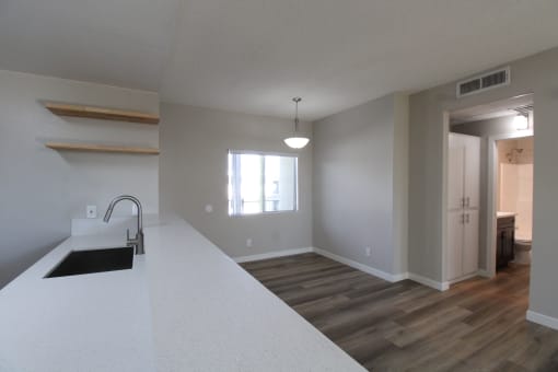 a kitchen and living room with a sink and a window