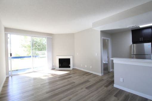 an empty living room with wood floors and a fireplace