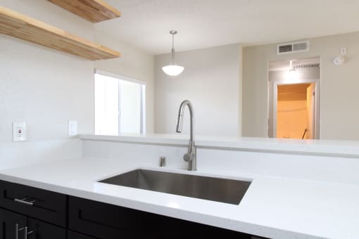 an empty kitchen with a sink and a faucet