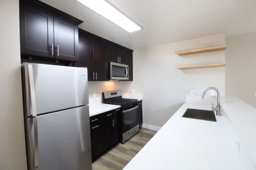 a kitchen with stainless steel appliances and black and white counter tops