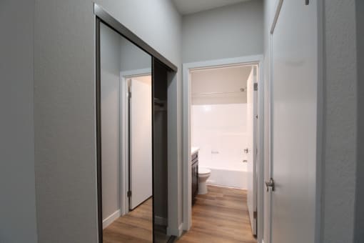 a view of the bathroom from the hallway with a door to the closet