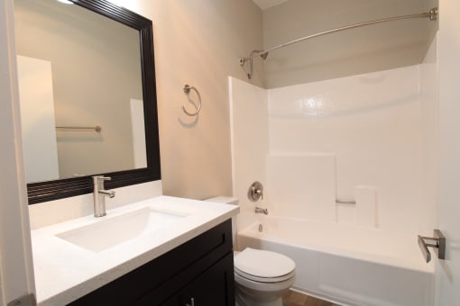 an apartment bathroom with a sink toilet and a bath tub