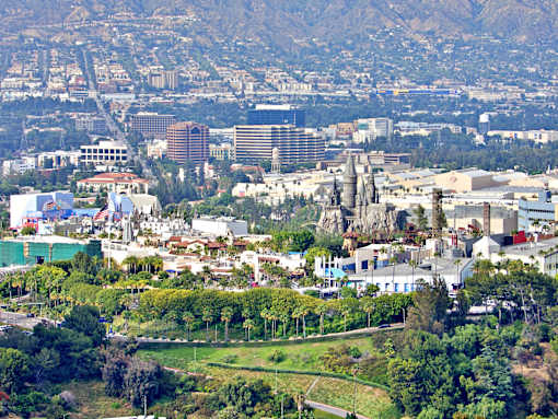 A cityscape with buildings and greenery in the foreground.
