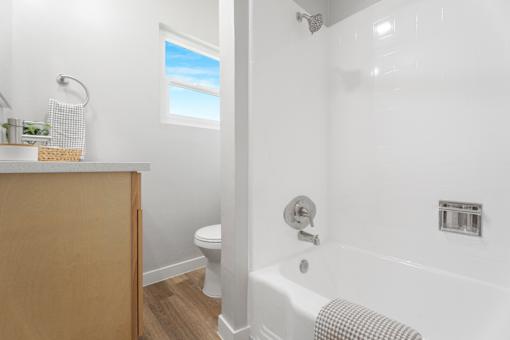 A white bathroom with a tub, toilet, and sink.