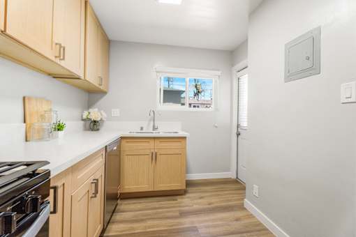 A kitchen with wooden cabinets and a black stove top.