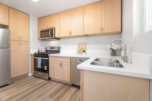 A kitchen with wooden cabinets and a stainless steel refrigerator.