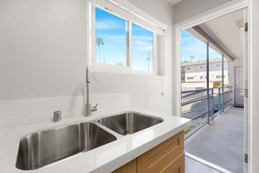A modern kitchen with a double sink and a window.