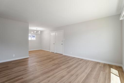 A room with wooden flooring and white walls.