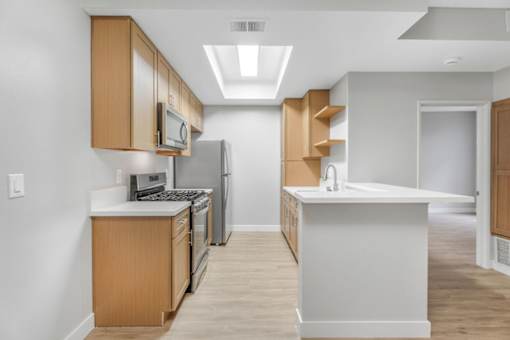 A kitchen with wooden cabinets and a white island.