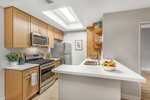 A modern kitchen with wooden cabinets and stainless steel appliances.