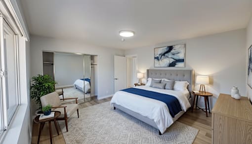 A bedroom with a large bed and a chair by the window.