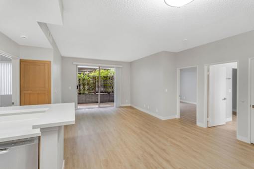 A spacious room with wooden floors and white walls.