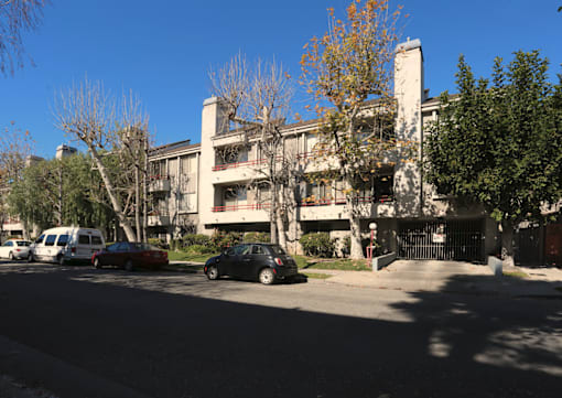 A car is parked on the street in front of a building.