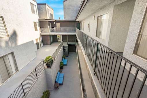 A balcony with a table and chairs is seen in the image.