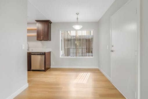 A kitchen with wooden floors and white walls.