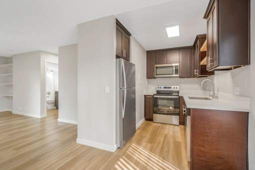 A kitchen with a refrigerator, oven, and microwave.