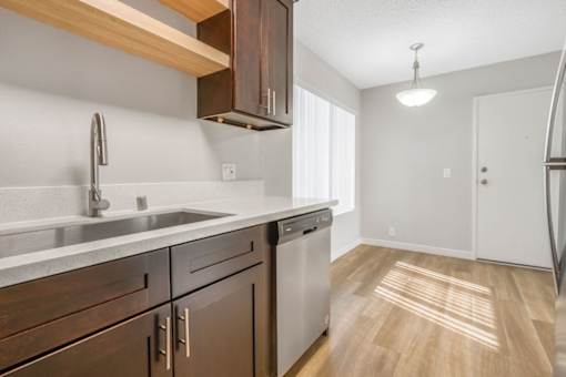 A kitchen with wooden cabinets and a stainless steel sink.