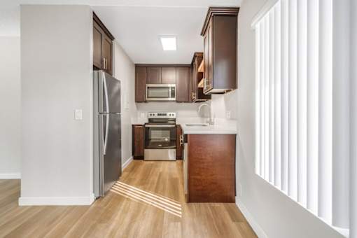 A kitchen with wooden floors and white walls.