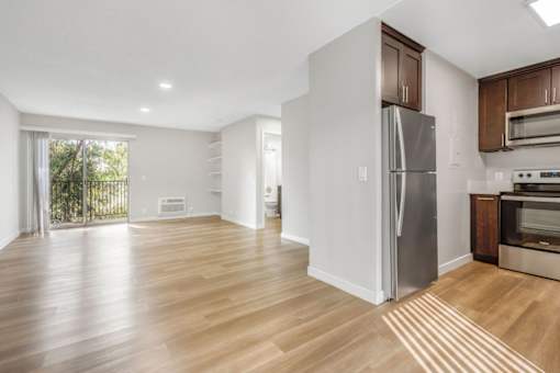 A kitchen with a refrigerator, oven, and microwave.
