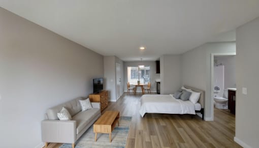 A spacious room with wooden floors and white walls.