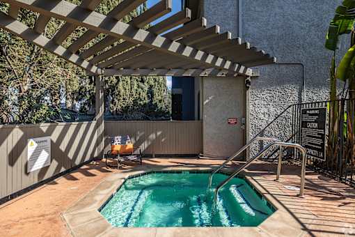 A small pool under a wooden pergola.