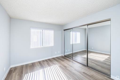 A room with a sliding glass door and wooden flooring.