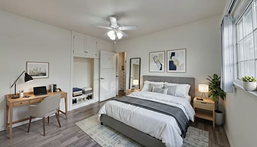 A bedroom with a bed, desk, and chair.