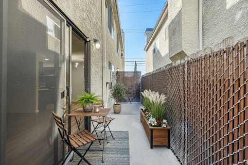 A patio with a table and chairs is surrounded by a brick wall.