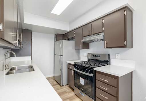 A kitchen with brown cabinets and stainless steel appliances.