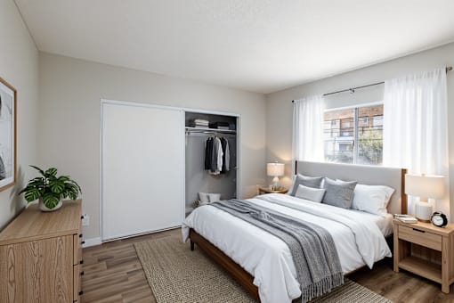 A bedroom with a large bed, a wooden nightstand, and a wardrobe.