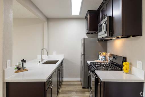 A kitchen with a white counter top and black appliances.