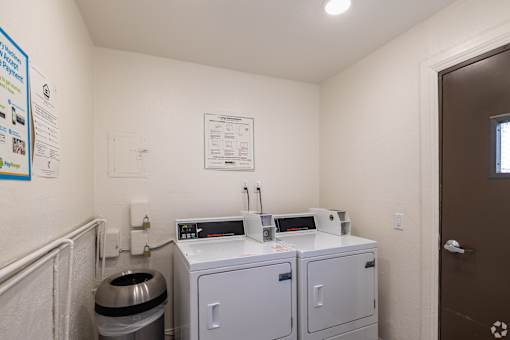 A small room with a toilet, a sink, and a trash can.