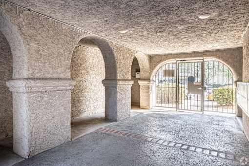 A room with arched columns and a tiled floor.