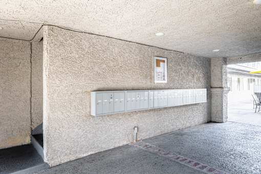 A concrete wall with a white electrical box mounted on it.