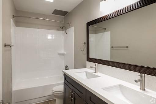 A bathroom with a white sink and a white toilet.