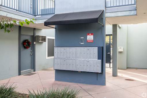A mailbox is located on the sidewalk outside a building.
