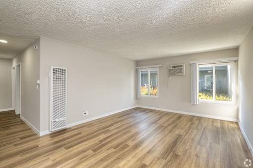 A room with wooden flooring and white walls.