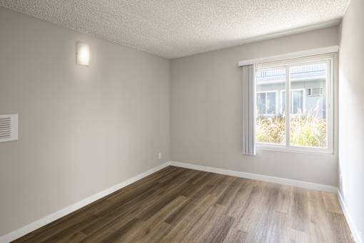 A room with wooden flooring and a window.