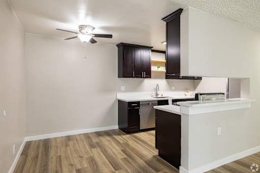A kitchen with a white counter and black cabinets.