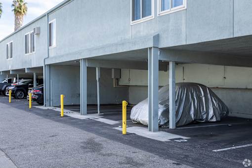 A parking garage with a car parked under a covered area.