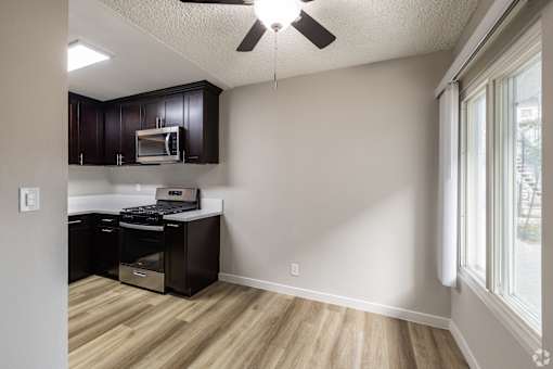 A kitchen with a microwave and oven built into the cabinetry.